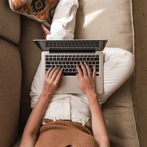 mujer con portatil en sofa